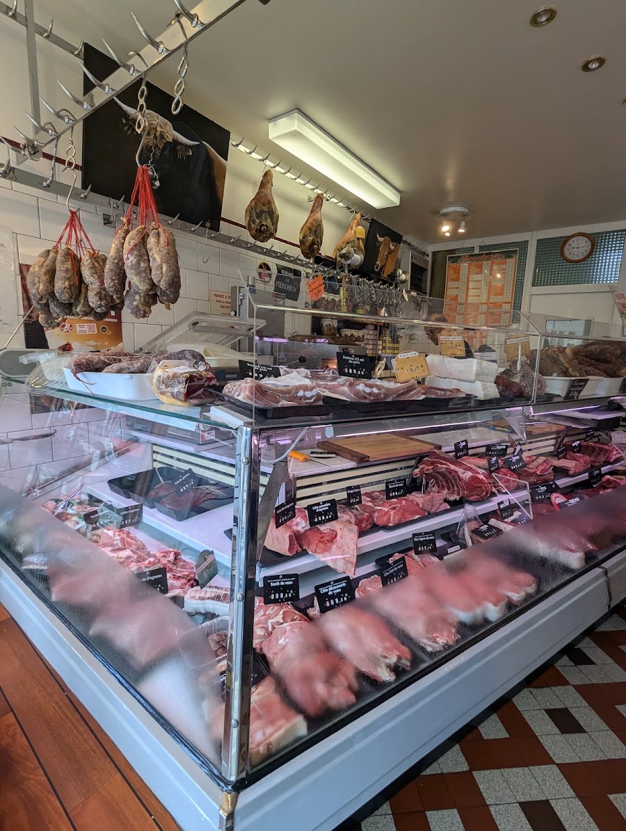 Le comptoir réfrigéré des viandes et les saucissons suspendus
